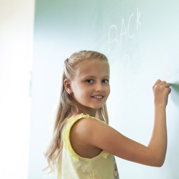 blonde-smiling-girl-writing-chalkboard
