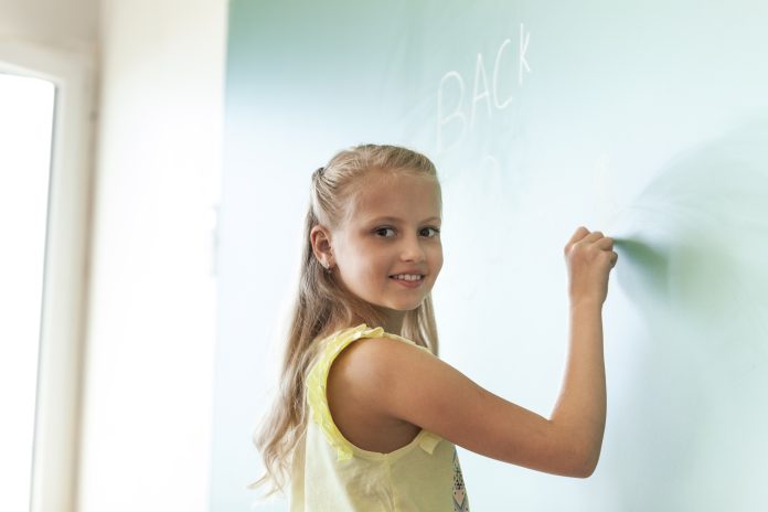 blonde-smiling-girl-writing-chalkboard